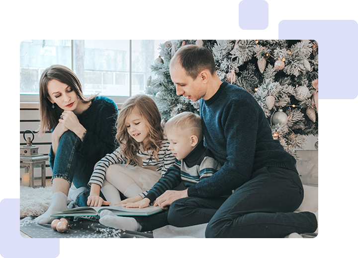 A family sitting on the ground with a book