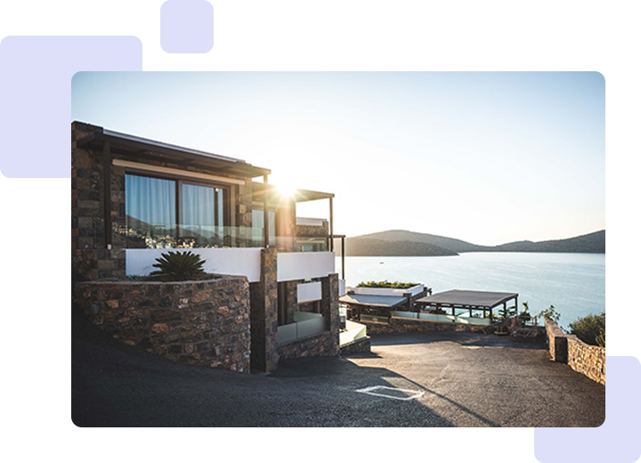 A house with a dock and a boat in the background.