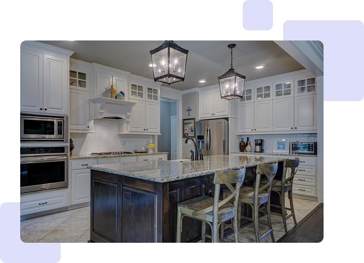 A kitchen with white cabinets and a large island.